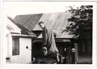 Paul Paulsberg vasker eller pusser sin Chevrolet Six lastebil på gårdplassen i Paulsberg. Våningshuset til venstre og låven bak. Foto: Ukjent, ca 1950-1960