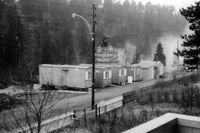 Fra anleggsarbeidene da deler av Prinsdalsbekken ble lagt i rør i 1964. Bak brakkeriggen ser vi stillaset med vaggen som fraktet den utsprengte massen opp til ventende lastebiler. Foto: Tor Harald Ruud (1964).