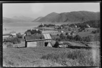 Handelsstedet til venstre, med kirken fra 1883 på neset i bakgrunnen. Forøvrig sees noe av den litt nyere bebyggelsen på stedet. Fotograf: Lyder Kvantoland 1948. Kilde: Nasjonalbiblioteket