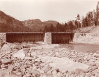 Rusdammen i vestre elveløp ut frå Fyresvatn. Vi ser at dammen er stemt med nåler og at det er ein del lekkasje mellom desse. Årstal 1914 og fotograf Olav S. Nylid
