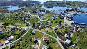 «Landsbyen i havet» i 2016. Den tette busetnaden med kyrkja sentralt gjer at Fedje liknar på ein landsby. Til høgre er ferjekaien, fryseriet og Bjelland med Vestkanten bakom. Foto: Arne Wiken