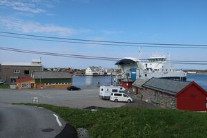 Ferjekaien i 2020 med venterommet til høgre. «Fedjebjørn» har lagt til kais. Til venstre fryseribygget og naustet med landhandelen. Bjelland (Fab. Nr 8) ligg i midten bak, og havstovene på Skotholmen til høgre.