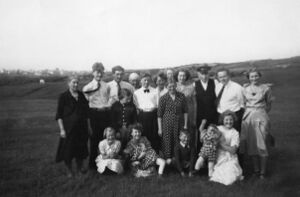 Nygård (bnr 16) i 1951. Bak frå venstre: Kristina, Gunnar, Georg, Gerda (framom), Kornelius Steffensen (bakom), Sigfred, Andrea, bakom Anna (g. Hansen), framom Anna (g. Nygård), Lovna Beate, Gregorius, Leif Larsen, Anita Johnsen. Framme frå venstre: Karin, Bjørg Johnsen m/Kari Larsen, Agnar, Torill Larsen, Kirsten.