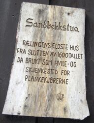 Sandbekkstua. Infotavle om plankekjørerne.
