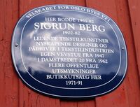 Blå plakett på veggen til Damstredet 5 i Oslo, hvor Berg bodde fra 1961. På den andre siden av gaten lå vevstuen hennes. Foto: Stig Rune Pedersen (2023).