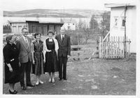 Turids konfirmasjon, 1957. Au da! Dårlig bakgrunn!! Skoledoene står, men låven er revet. Kjøkkeninngangen til lærer Rustøys leilighet til høyre, og porten inn til deres del av hagen.