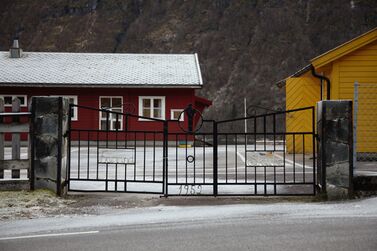 Ein port i smijarn. Han er tredelt, kor orda "Fjærland" og "skule" er smidd inn midt i portane til høgre og venstre, mens årstalet 1952 er smidd inn i midten. "Fjærland skule" og "1952" er kvitmalt.