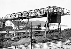 Lossekran på Slemmestad som losser en lekter med kalksteinsmasse fra Langøya. Foto: Cementfabrikkens jubileumstidskrift 1942, s. 145