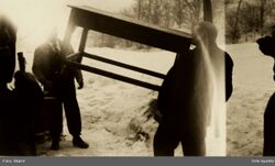 Bestyrer Nielsen viser krefter og bærer et bord med tennene. Foto: Oslo byarkiv (1920).