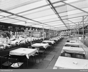 Restaurant Kabas uteservering på terrassen ved hovedinngangen mot Stortingsgata som går til venstre. Nationaltheatret kan skimtes midt på bildet, under baldakinen. Foto: Leif Ørnelund/Oslo Museum (1965).