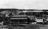 Strømmen Trævarefabrik med jernbrua fra 1908 helt til høyre i bildet.