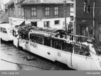 Trikken som brant i 1958 på ulykkesstedet. Tilhenger 198 er helt ødelagt, mens motorvogn 194 bare fikk overfladiske skader. I bakgrunnen på høyre side Totengata 1 med store utvendige skader. Foto: Per Lyng (1958).