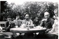 Fra venstre: Turid Veiby, Torill Paulsen, Stener Røstø, Hanse Røstø og Hanna Paulsen rundt steinbordet i "syrin-lysthuset" på Engeli.jpg. Foto: Ukjent, omkring 1954