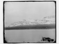 Utsikt over en sjø og fjell i bakgrunnen. Men hvor? Foto: Marthinius Skøien (omkr. 1880-1910).