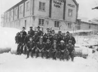 Arbeidsstokken ved fabrikken, med fabrikkbygningen i bakgrunnen.